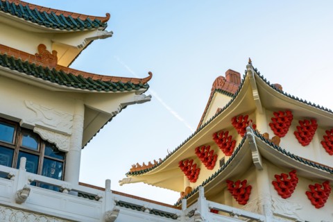 View of the chinese-inspired architecture of the Huatian Chinagora hotel complex with curved roof corners and traditional glazed roof tiles.