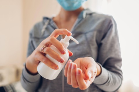 Corona virus covid-19. Woman washes hands with alcohol gel antibacterial soap sanitizer wears medical mask. Healthcare