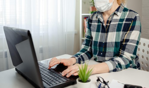 Woman in medical mask working office work remotely from home