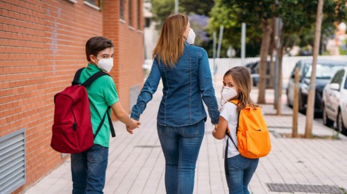 Mother with her children go to school with masks in coronavirus pandemic
