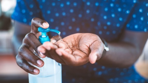 African man cleaning hands with sanitizer gel for protect coronavirus or covid-19
