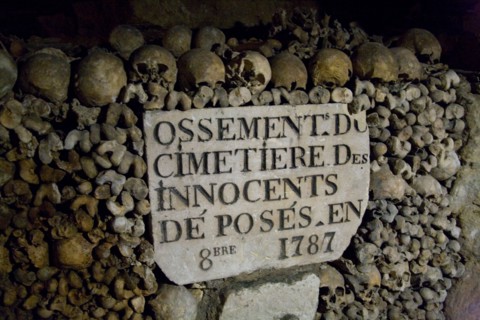 Human skulls and bones stacked in rows in the underground Catacombs, Paris, France.