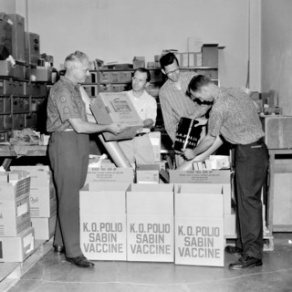 Four men unpack the Sabin polio vaccine for a publicity photo in California, ca. 1962.