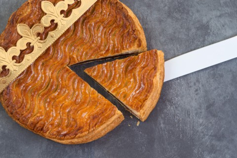 Galette des rois, french kingcake with a golden crown on a grey slate background