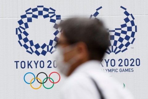 Tokyo, Japan. 18th June, 2020. A man wearing a face mask walks past the logos of Tokyo 2020 Olympic and Paralympic Games in downtown Tokyo. Japanese media reported that an executive board member of To...
