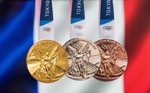 April 25, 2021 Tokyo, Japan. Gold, silver and bronze medals of the XXXII Summer Olympic Games 2020 in Tokyo on the background of the flag of France.