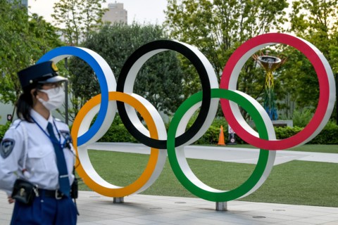Tokyo, Japan. 09 May, 2021. A Policewoman seen near the Olympic Rings during a protest against the Tokyo Olympics in front of the New National Stadium, the main stadium for the Tokyo Olympics. Credit:...