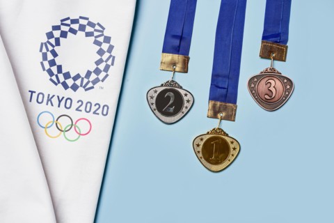 Tashkent, Uzbekistan - March 4, 2021: 2020 Summer Olympic Games logo on white towel and Golden, Silver and Bronze olympic medals