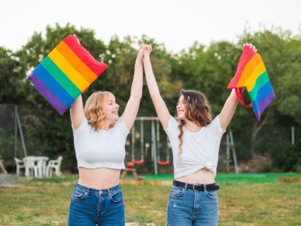 Young caucasian females holding the LGBT flags