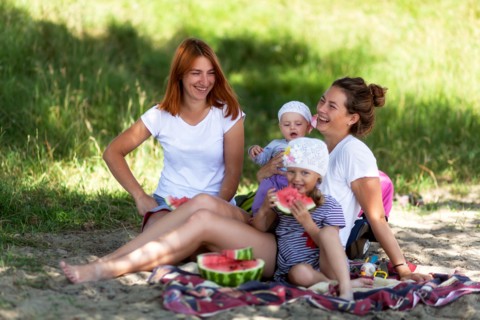 Concept for togetherness and bright future.Two beautiful women with a baby on the picnic  in park at  during vacation  Couple lovers woman smile and e