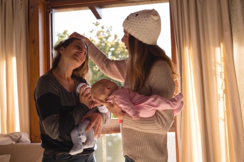 Lesbian couple holding their babies