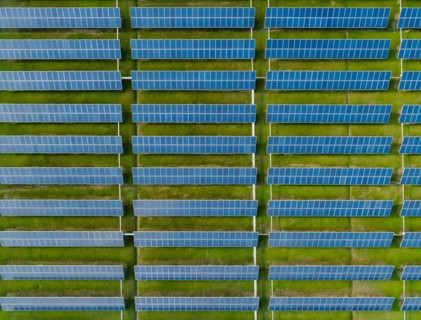 Aerial view of Solar Panels Farm with sunlight. Drone flight over solar panels field, renewable green alternative energy concept.
