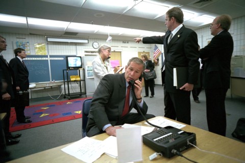 As Dan Bartlett, Deputy Assistant to the President, points to news footage of the World Trade Center Tuesday, Sept. 11, 2001, President George W. Bush gathers information about the terrorist attack fr...