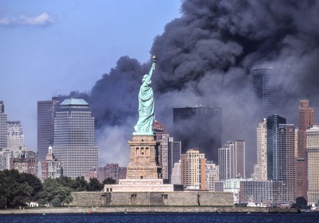 Sept. 11, 2001 - New York, New York, US - The Statue of Liberty stands against the backdrop of billowing clouds of smoke and debris over lower Manhattan after terrorists crashed two hijacked airliners...
