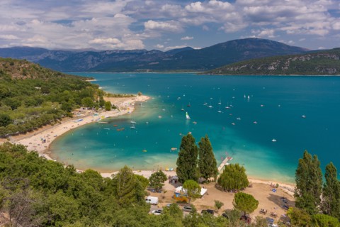 LAKE OF SAINTE-CROIX, PROVENCE, FRANCE - People on beach and in boats at man-made lake, lac de Sainte-Croix.