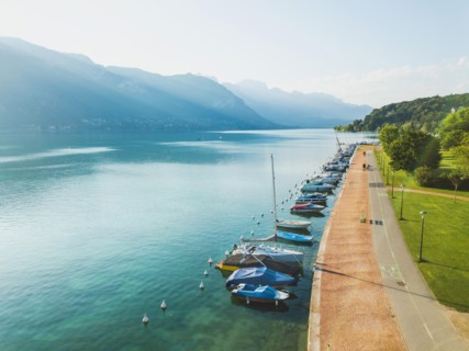 aerial landscape of Annecy lake, Alps, France, yachts and sailing boats from above, pedestrian walk near crystal blue water