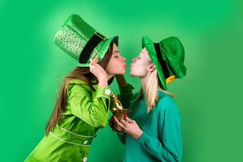 Irish traditions. Young women celebrating St Patrick's Day in pub. Isolated.