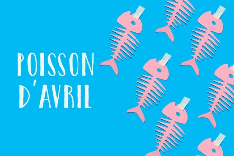 some homemade pink paper fishes and text fish of april written in french, the equivalent of april fools day in france, where it is popular to attach p
