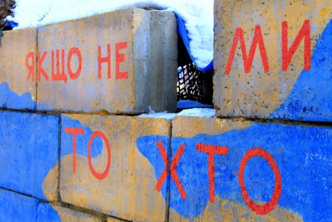 Armed conflict east Ukraine, Ukrainian war. A checkpoint of army in colors of Ukraine flag with patriotic inscription in Ukrainian - If not us, then w