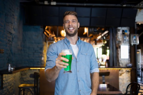 Handsome man holding a beer in a pub for St. Patrick's Day