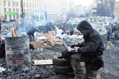 Kiev, Ukraine. 02nd Feb, 2014. A man sits with a laptop near to a fire at the so-called EuroMaidan demonstrations that began after plans for closer integration with Europe were scrapped in November 20...