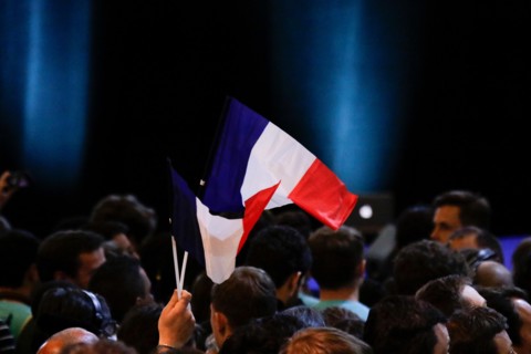 Paris, France. 23rd Apr, 2017. A Macron supporter waves a French flag while waiting for the polling stations to close. Supporters of Emmanuel Macron, the Presidential candidate from the social liberal...
