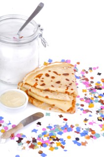 french pancakes wiht pot of butter an sugar on confetti on white background