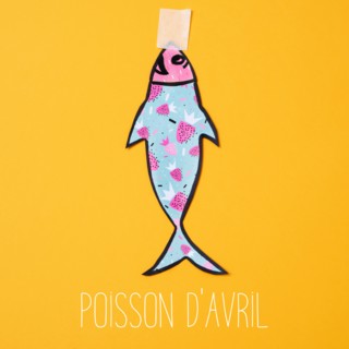 a homemade paper fish, made by myself, attached with adhesive tape to an orange background and the text poisson d avril, april fools day in french