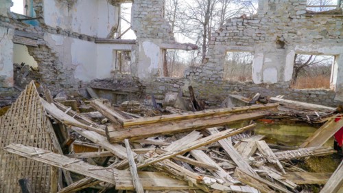 Lots of wooden rubbles on the floor of the house that was damaged during the war in ukraine