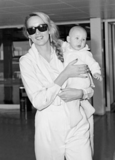 Texan model and wife of Mick Jagger, Jerry Hall leaving London's  Heathrow Airport with baby daughter Elizabeth in August 1984.