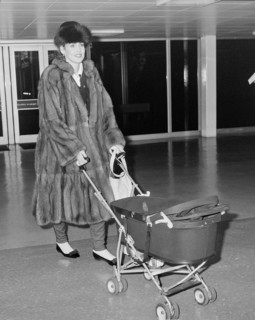 Texan model and wife of Rolling Stone Mick Jagger arriving at London's Heathrow Airport with daughter Elizabeth Scarlett in 1985.