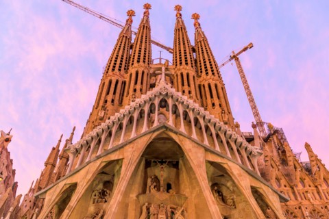 Sagrada Familia - A close-up wide-angle view of west Passion facade of Basílica de la Sagrada Família, against colorful Autumn sunset sky. Barcelona.