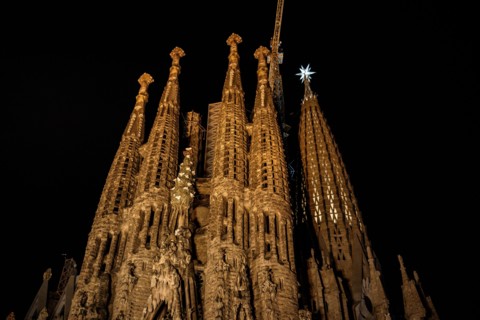 Façana del Naixement (Facade of the Birth) and the star of the Mary tower illuminated at night in the Sagrada Familia (Barcelona, Catalonia, Spain)