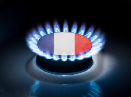 Burning gas burner of a home stove in the middle of which is the flag of the country of France. Gas import and export delivery concept, price per cubi
