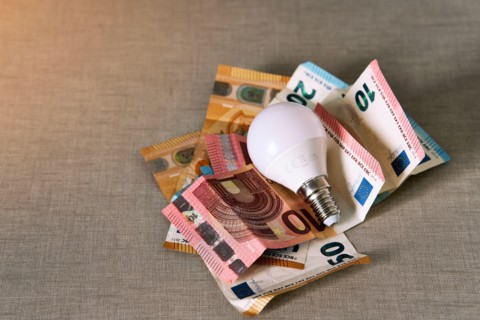 Several euro bills with a light bulb representing the rise in the price of electricity