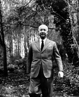 Fashion designer Christian Dior walking in the woods