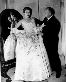 Fashion designer Christian Dior fitting a woman's gown