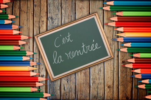 Wooden textured table from above and back to school concept in french