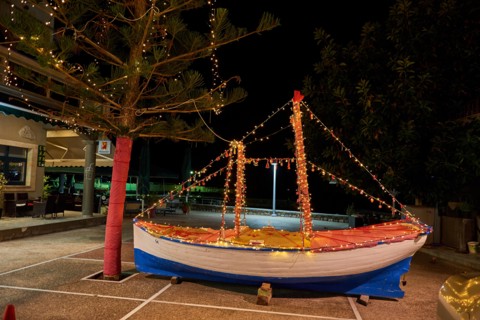 Wooden Christmas ship decorated at night. In the Greek tradition (especially in the islands) it is common to ornament a ship instead of a tree for Ch