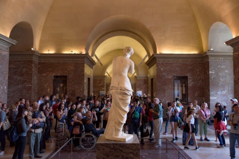 People around Venus de Milo (Aphrodite of Milos), one of the most famous ancient Greek sculpture, on display at the Louvre Museum in Paris, France