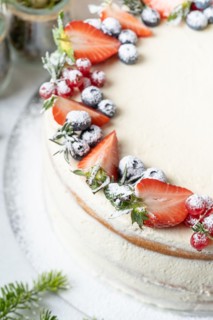 Homemade birthday cake for New year and Christmas. Christmas tree branches for decorating the Christmas table.