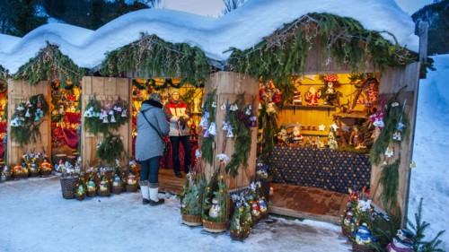 Romantic christmas market in Bavaria with illuminated wooden shops in snow
