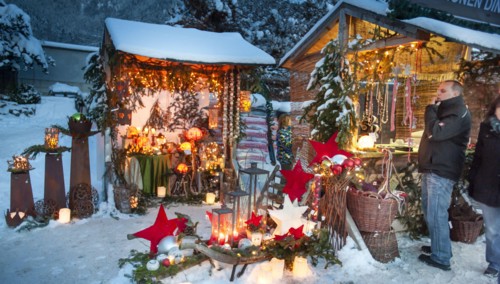 Romantic christmas market in Bavaria with illuminated wooden shops in snow