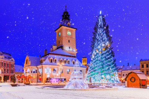 Brasov, Romania. Old Town Christmas Market at twilight with snow effect.
