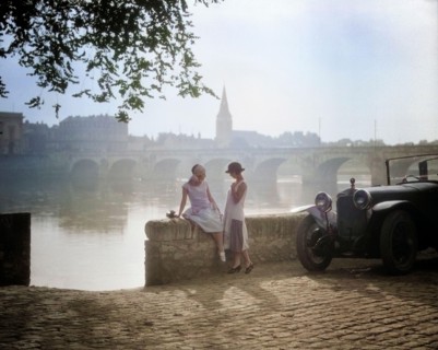 1920s TWO YOUNG WOMEN WITH ANTIQUE AUTOMOBILE SITTING STANDING TOGETHER TALKING BY STONE WALL LOIRE RIVER