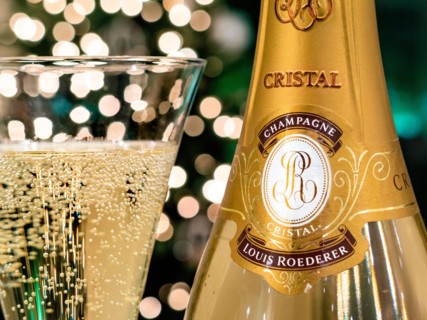CRISTAL CHAMPAGNE Bottle and freshly poured glass of Louis Roederer Cristal luxury champagne with sparkling party celebration  lights in background
