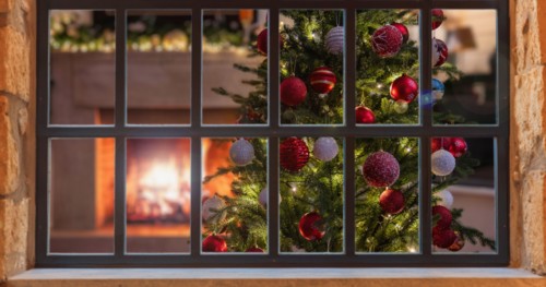 Christmas window. Xmas tree decoration, burning fireplace, winter holiday home interior, view from outdoors