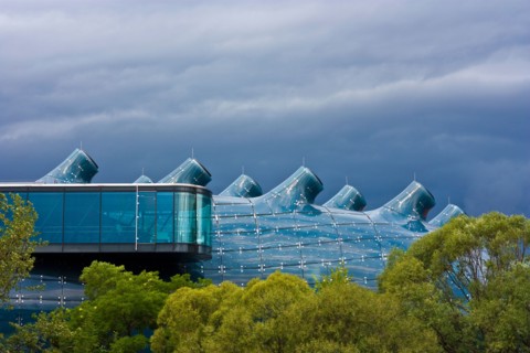Kunsthaus Graz, a huge bluish bubble called "friendly alien" is the art gallery from Graz, Styria, Austria. Dark clouds before r