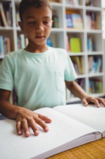 Boy using braille to read