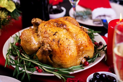 Baked turkey. Christmas dinner. The Christmas table is served with a turkey, decorated with bright tinsel and candles. Fried chicken, table.  Family d
